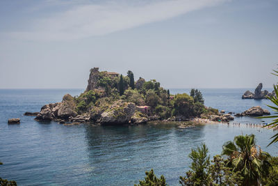 Scenic view of rocks on sea against sky