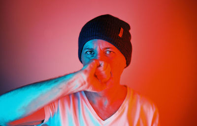 Portrait of man against orange background