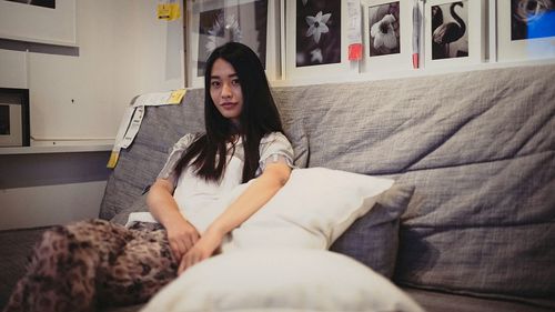 Portrait of young woman lying on bed