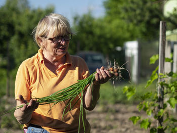 Woman with arms raised against plants