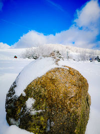 Scenic view of snow covered mountains against blue sky