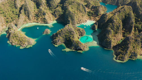 Aerial drone lagoons and coves with blue water among the rocks.  kayangan covered with forests.