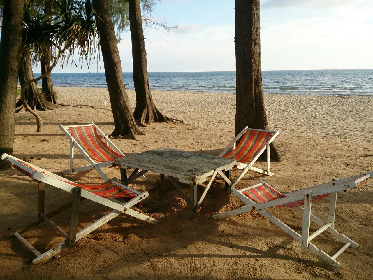 sea, beach, horizon over water, sand, water, shore, chair, tranquility, sky, absence, tranquil scene, scenics, empty, deck chair, nature, lounge chair, beach umbrella, vacations, tree, beauty in nature