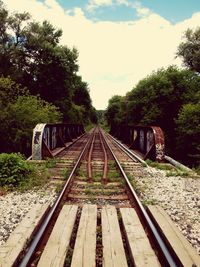 Railroad tracks amidst trees against sky