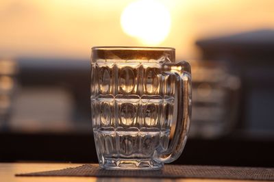 Close-up of glass on table during sunset