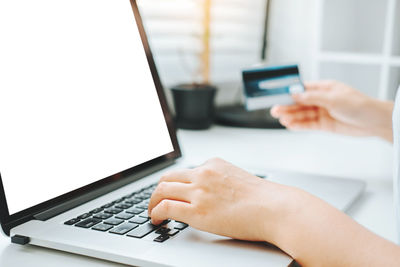 Midsection of woman using laptop on table