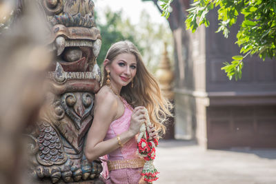 Young woman with sculpture in temple