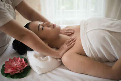 Midsection of therapist massaging young woman in spa