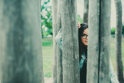 Portrait of woman by tree trunk