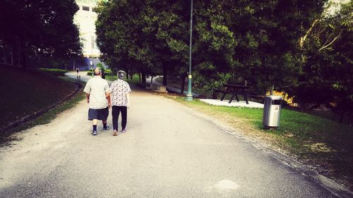 Rear view of people walking on road