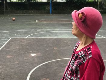 Side view of senior woman standing at basketball court