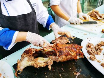 Midsection of man preparing food on barbecue grill