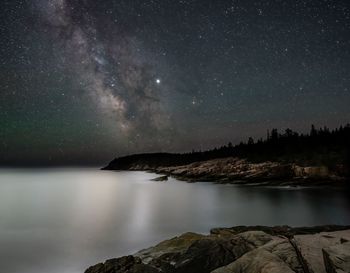 Scenic view of lake against sky at night