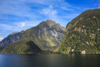 Scenic view of lake by mountains against sky