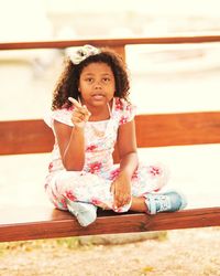 Portrait of smiling girl sitting outdoors