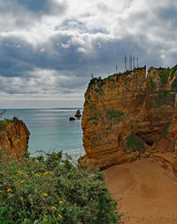 Rock formations by sea against sky