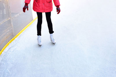 Low section of woman ice-skating on snow