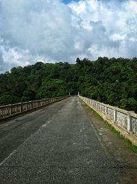 Road amidst trees against sky