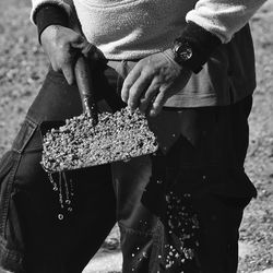 Man holding sand in shovel at beach