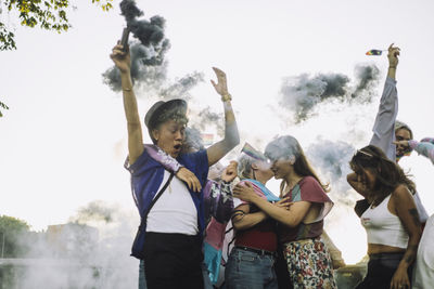 Happy friends enjoying while dancing together during lgbtqia rights parade