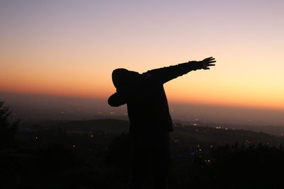 Silhouette man standing against clear sky during sunset