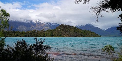 Scenic view of sea and mountains against sky