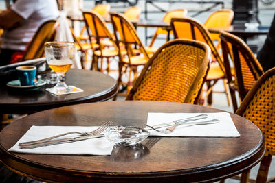 Empty tables and chairs at sidewalk cafe