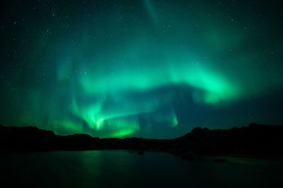 Low angle view of aurora borealis over lake