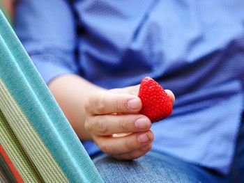 Close-up of hand holding strawberry