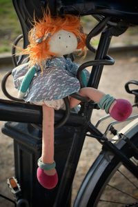 Toy on bicycle by railing