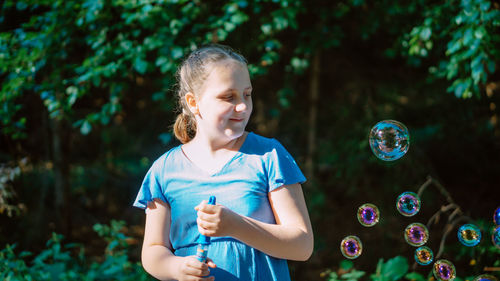 Portrait of young girl blowing bubbles