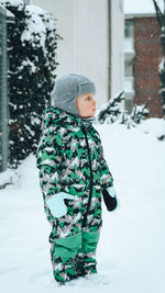 Cute boy walking in snow during winter