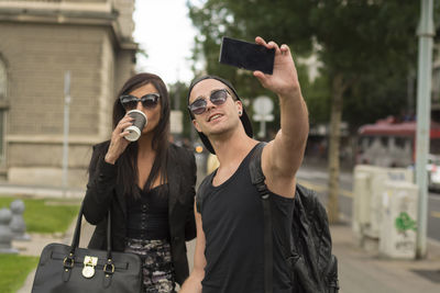 Man taking selfie with friend while standing on road