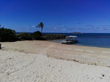 Boat on beach against clear blue sky