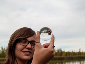 Teenage girl holding crystal ball while standing outdoors