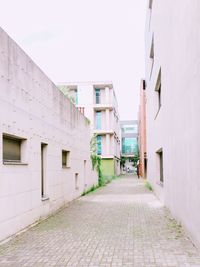 Walkway amidst buildings against sky