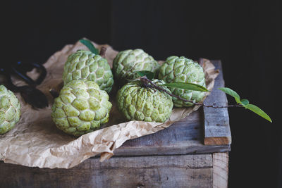 Custard apples on paper over wooden table