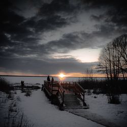 Scenic view of snow covered land against sky during sunset