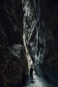 Full length of man standing on rock in cave