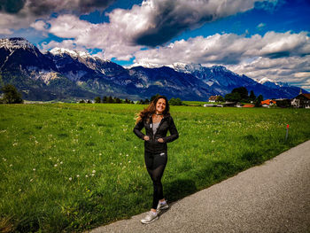 Portrait of woman standing on field against mountains