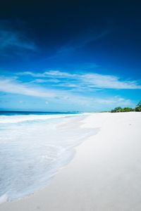 Scenic view of beach against blue sky