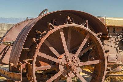 Close-up of old metal wheel against sky