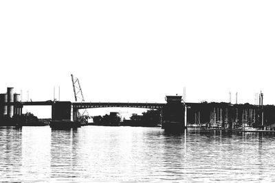 Wooden posts in river against clear sky