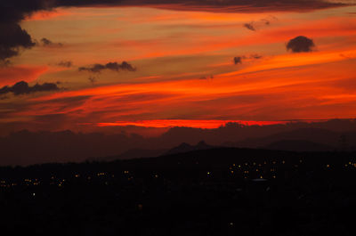 Scenic view of dramatic sky over silhouette landscape