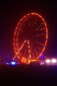 Illuminated ferris wheel at night