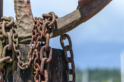 Close-up of rusty chain against sky