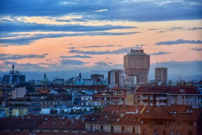 View of cityscape against cloudy sky