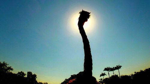 Low angle view of silhouette tree against blue sky