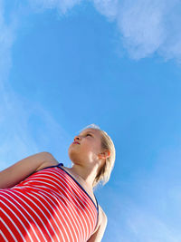 Low angle portrait of girl looking at blue sky
