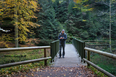 Rear view of woman walking on footbridge